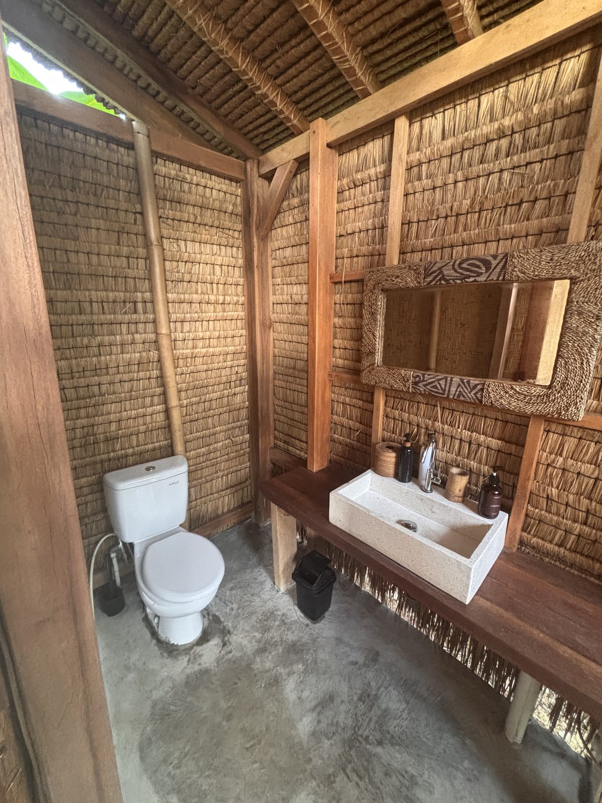 Big Bungalow rustic bathroom with thatched walls and stone sink