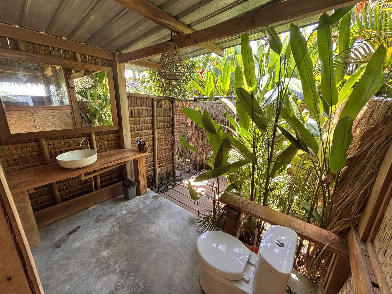 Outdoor toilet area at Small Bungalow surrounded by tropical greenery